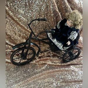 Vintage porcelain sitting Doll on Black Tricycle